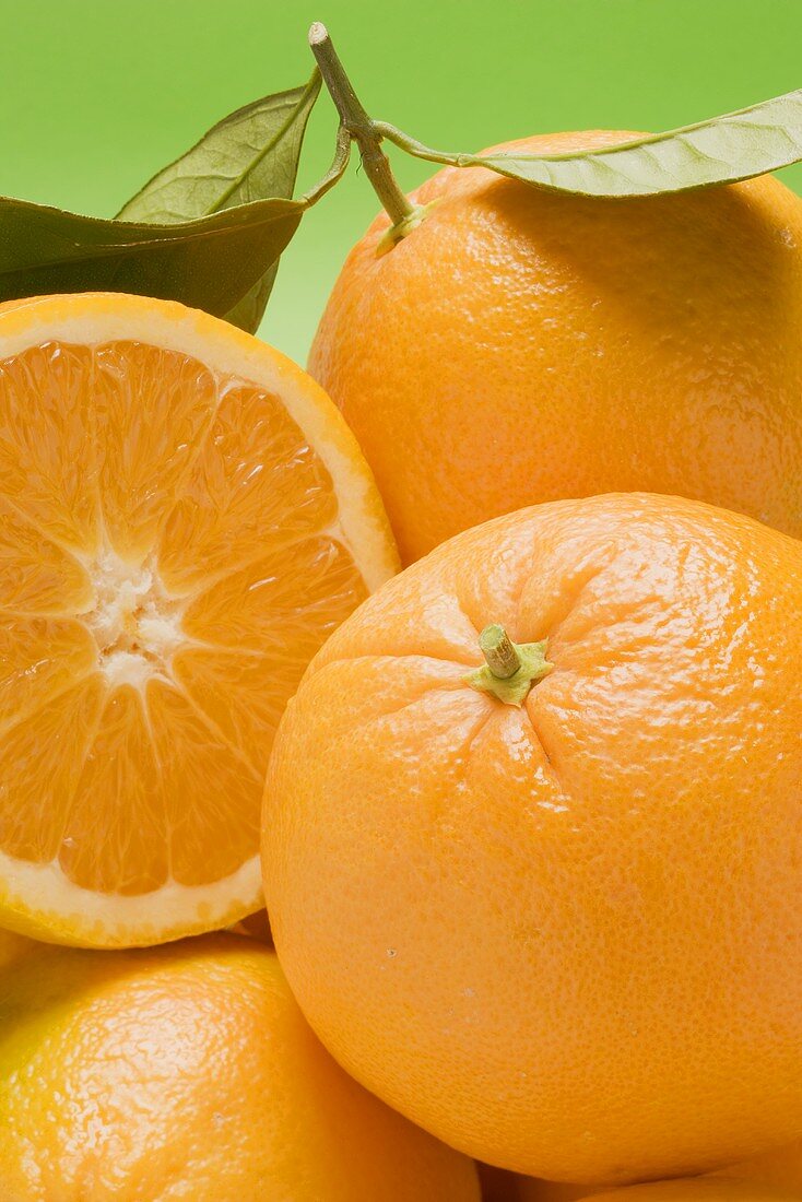 Oranges, whole and halved, with leaves