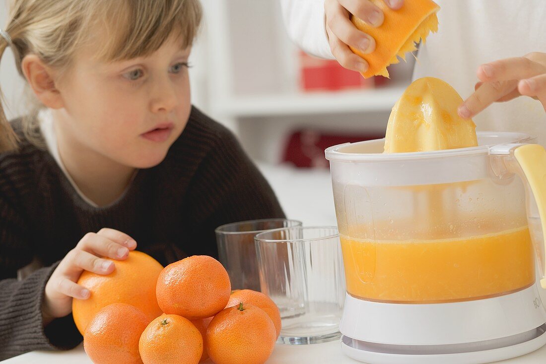 Kinder pressen Orangen aus