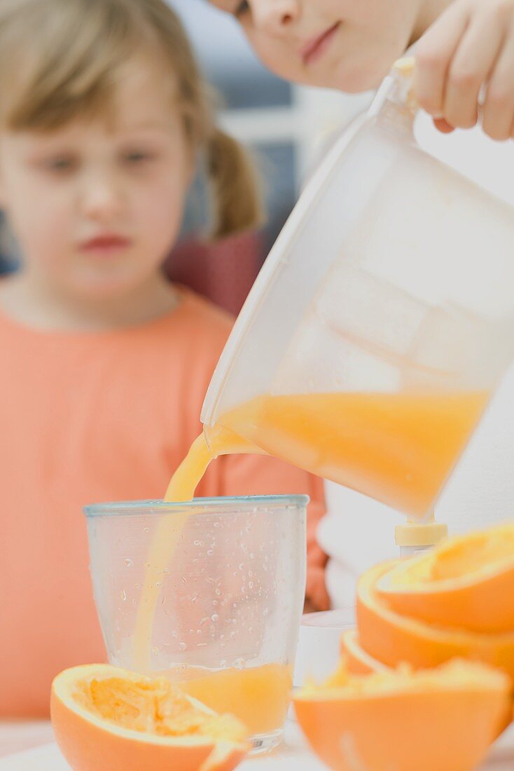 Children squeezing oranges