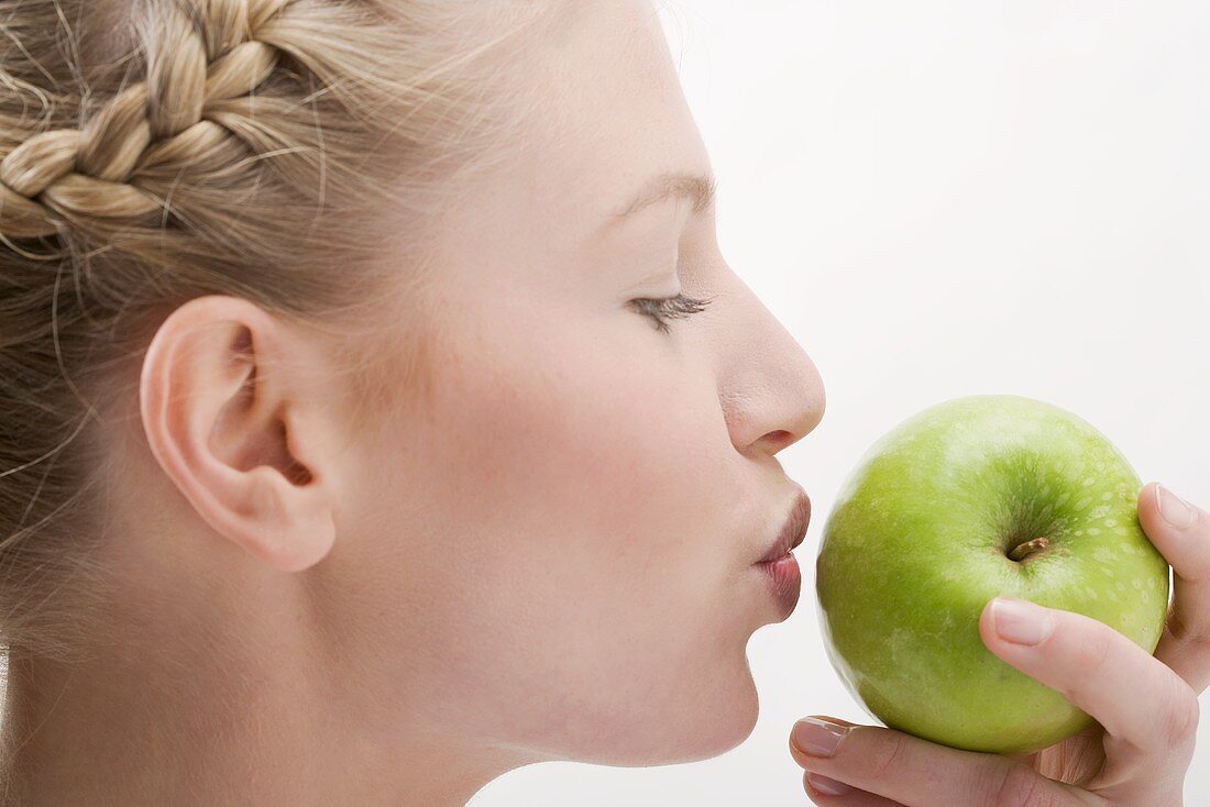 Frau küsst grünen Apfel