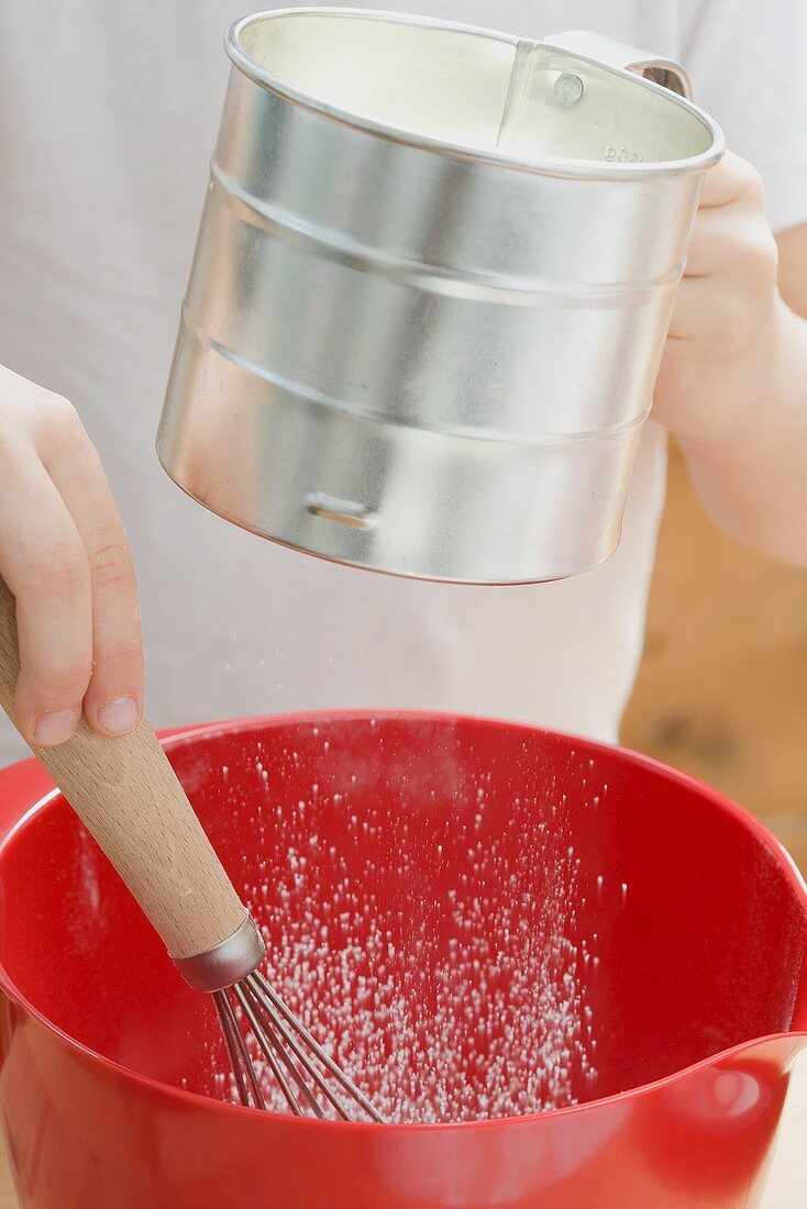 Child sifting flour
