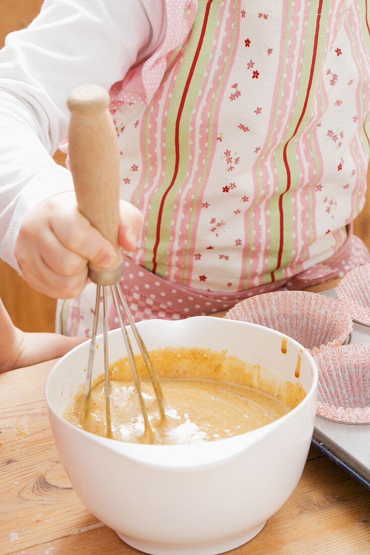 Child stirring muffin mixture