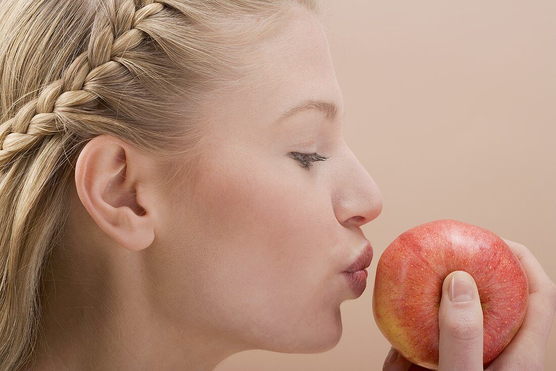Woman kissing red apple
