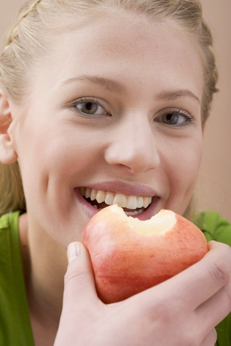 Frau hält angebissenen Apfel