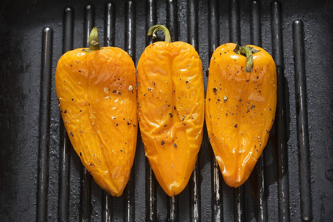 Three yellow peppers in a grill frying pan