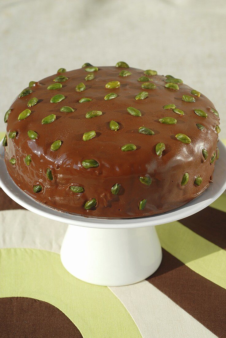 Whole pineapple cake with chocolate icing and pistachios