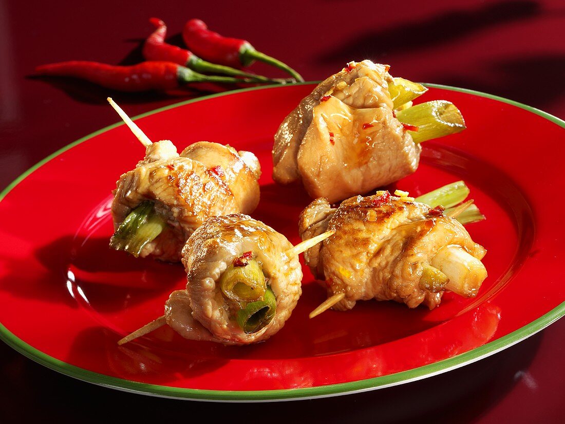 Marinated turkey rolls with spring onions on cocktail sticks