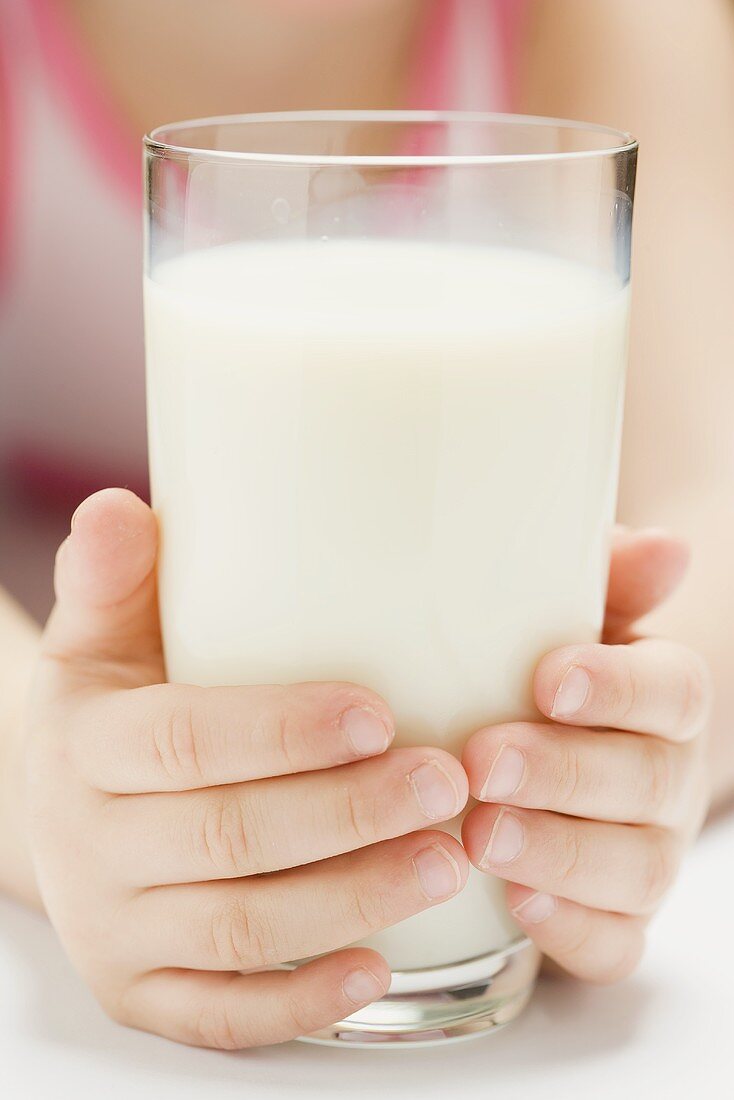Child holding glass of milk