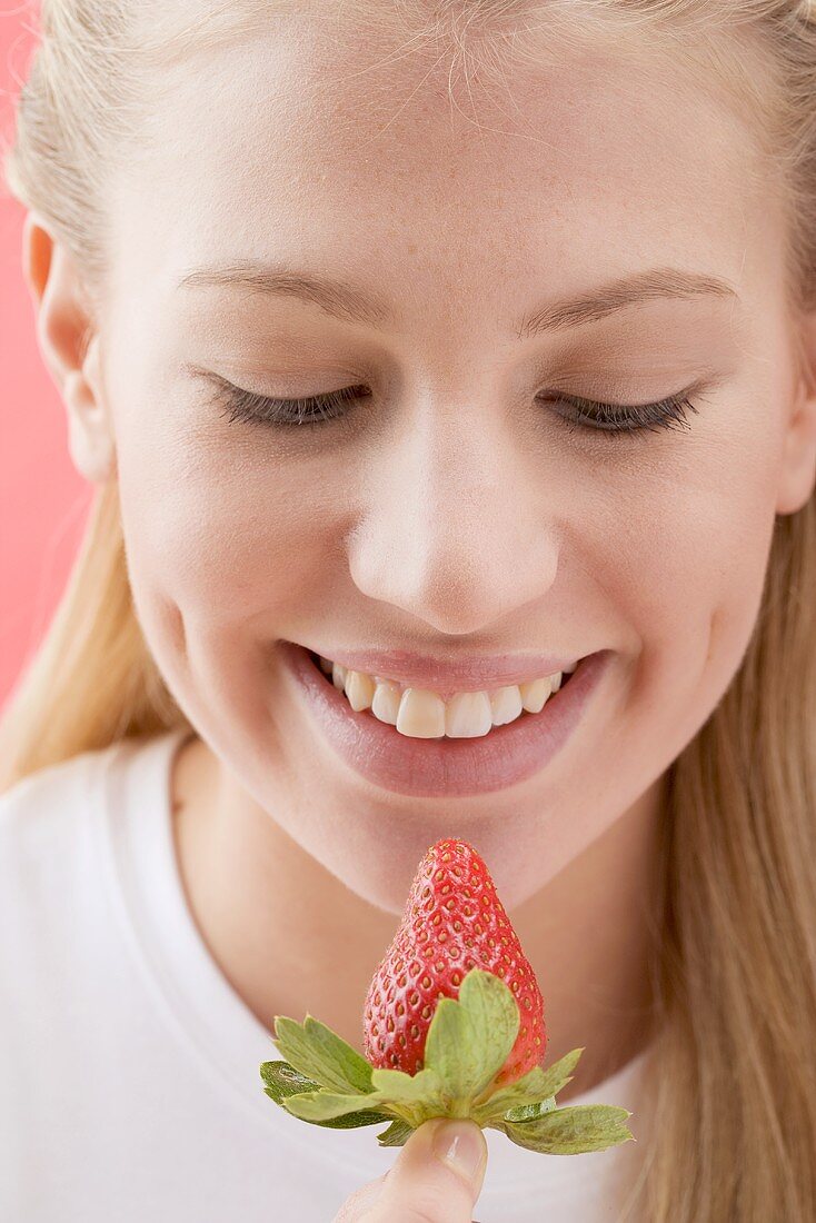 Woman looking at a strawberry