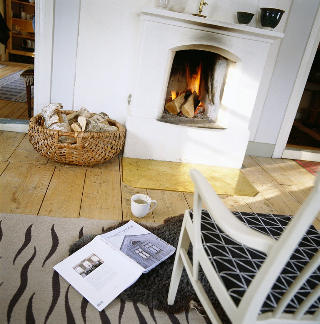 A chair, a book and a cup of tea in front of an open fire