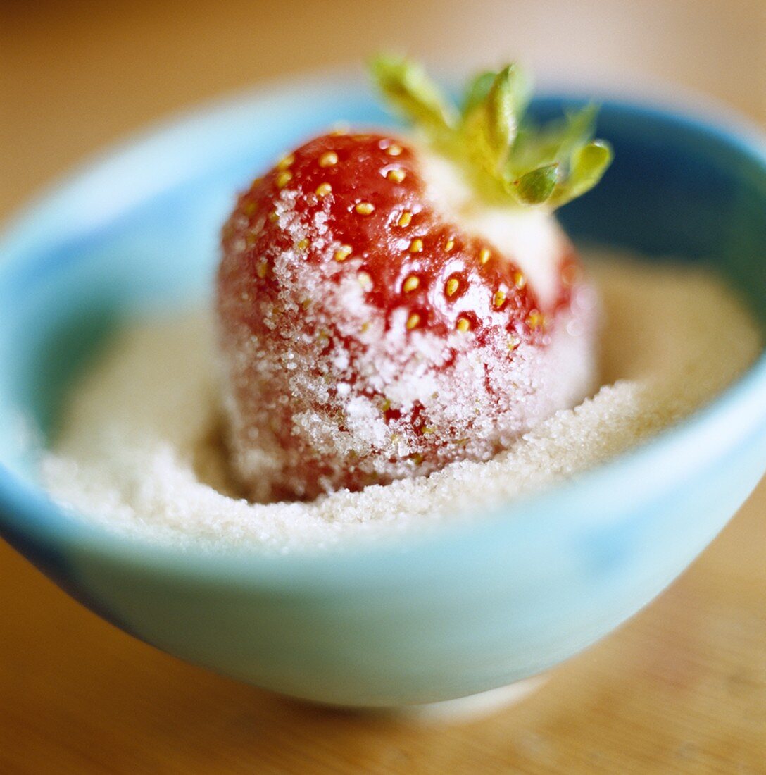 Eine Erdbeere in Zucker getaucht