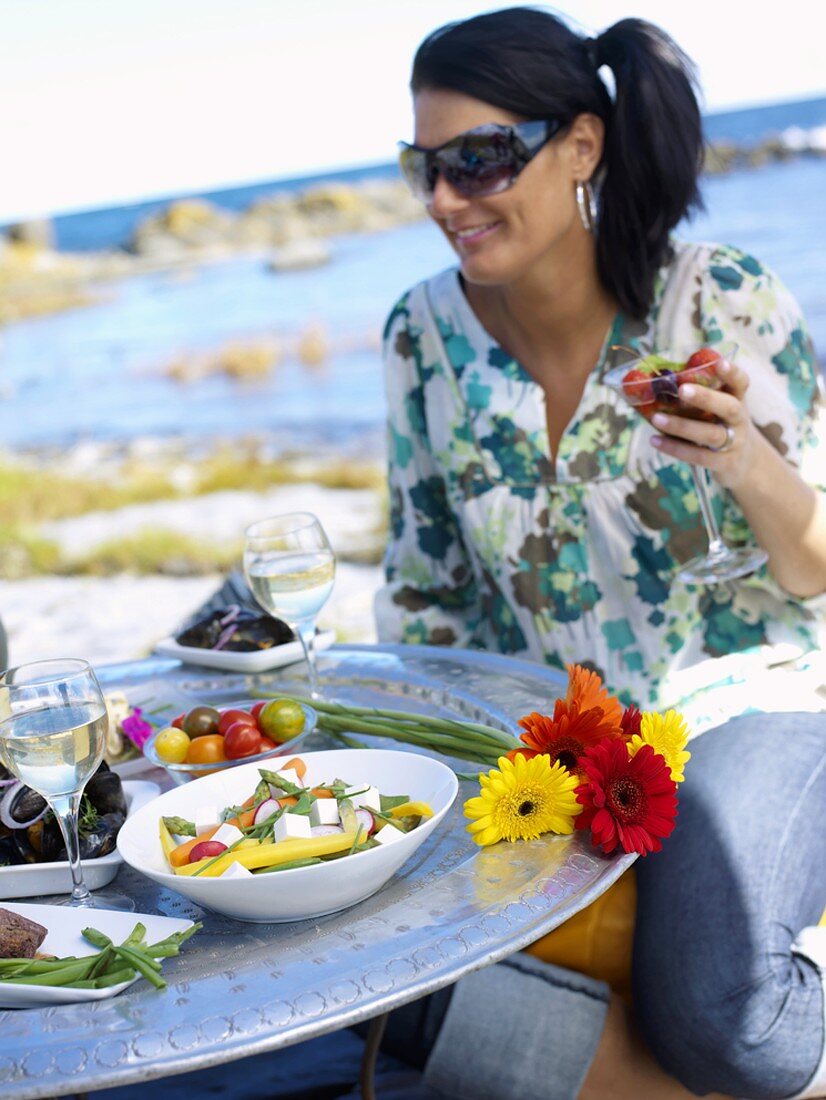 Black-haired woman picnicking by the sea