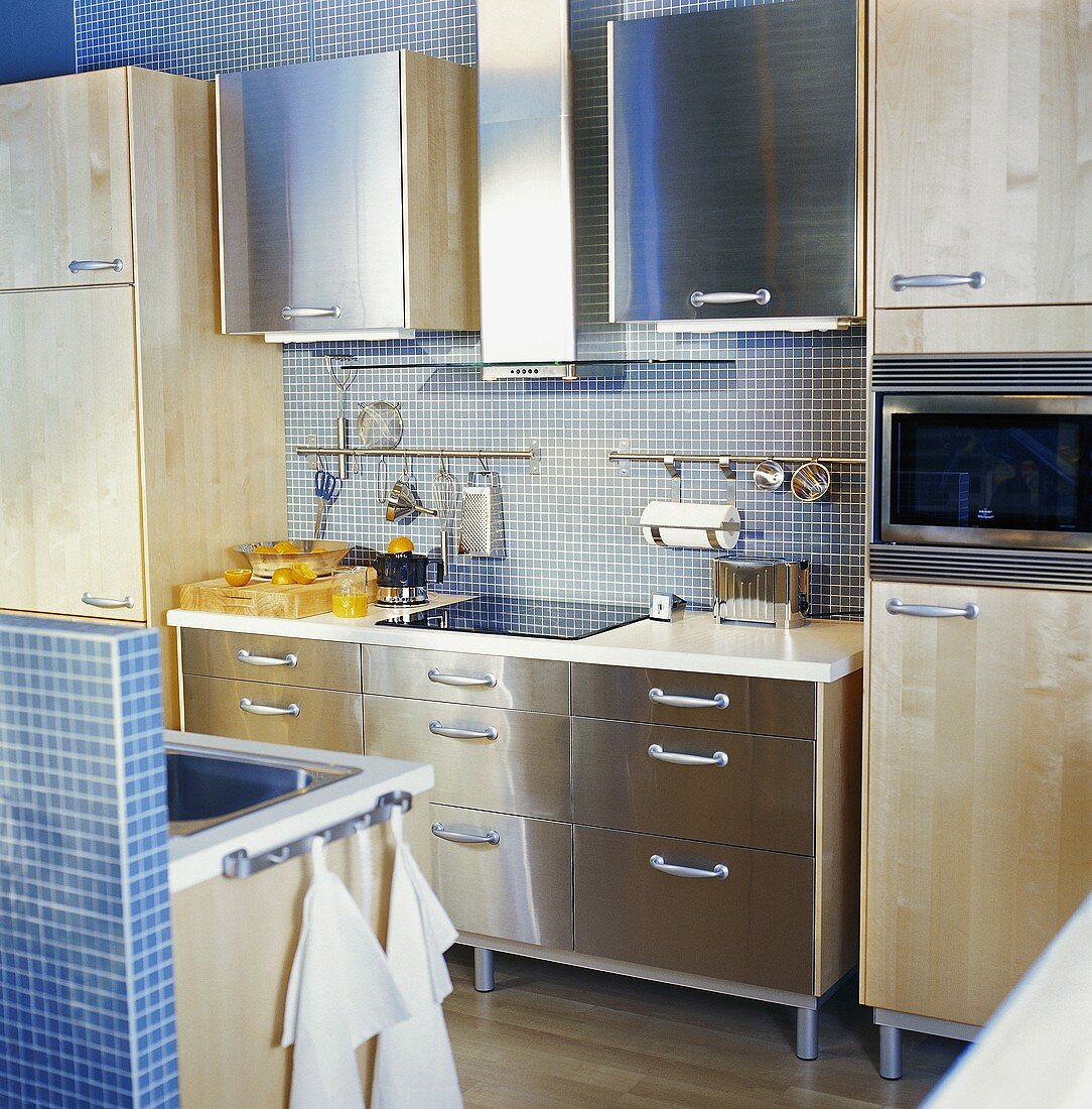 Moderne Küche mit blauen Mosaikfliesen, Edelstahl- und Holzfronten