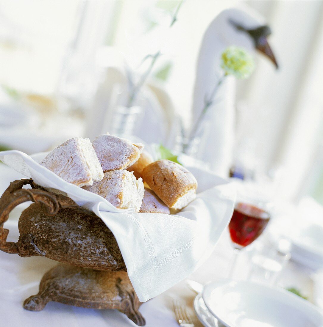 Bread rolls and red wine on laid table