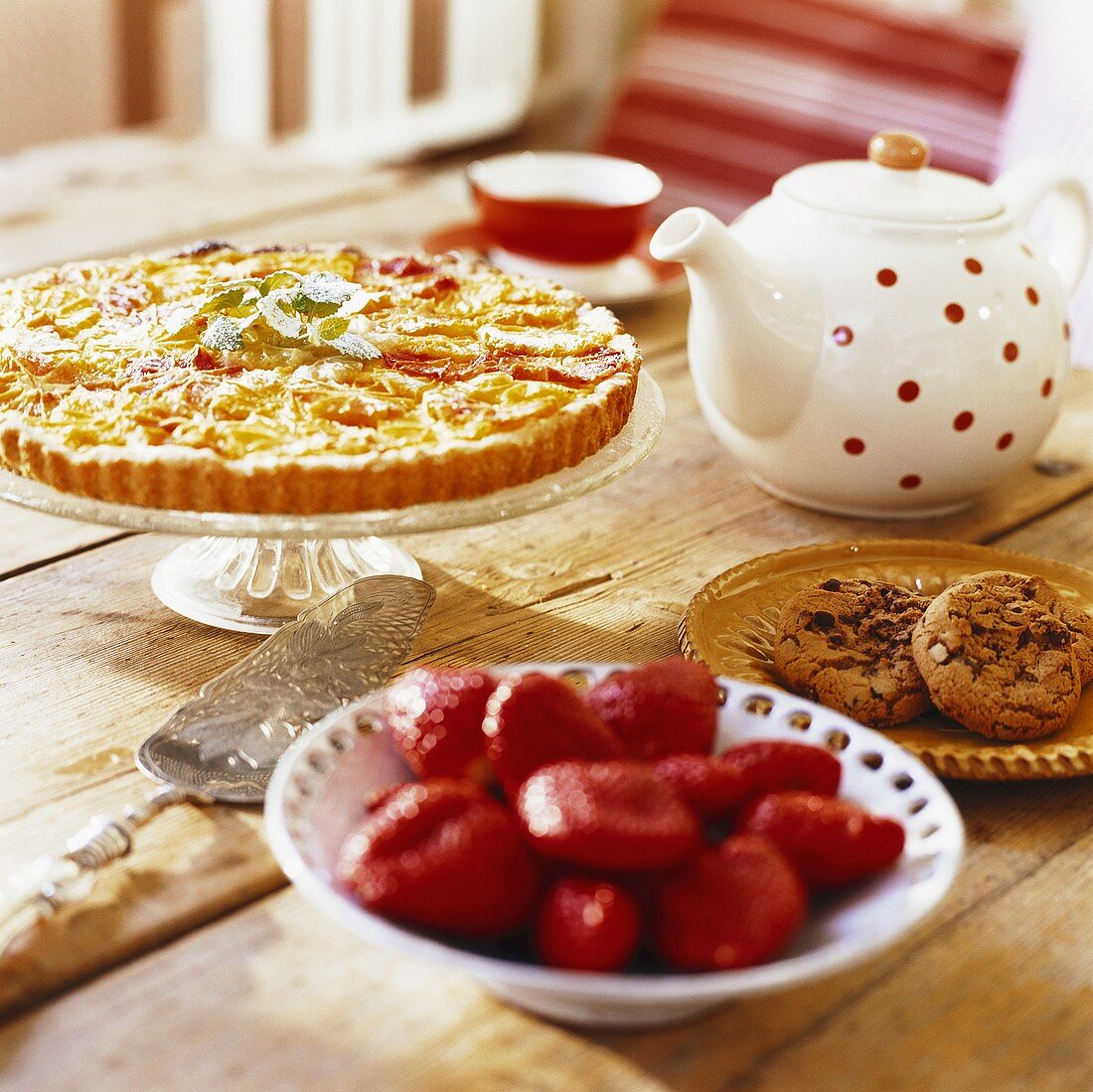 Fresh strawberries, tart, teapot and cookies