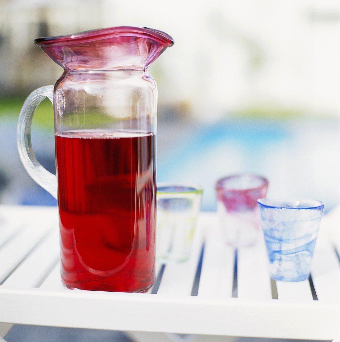 Fruchtsaft im Krug und Gläser auf einem Tisch im Freien