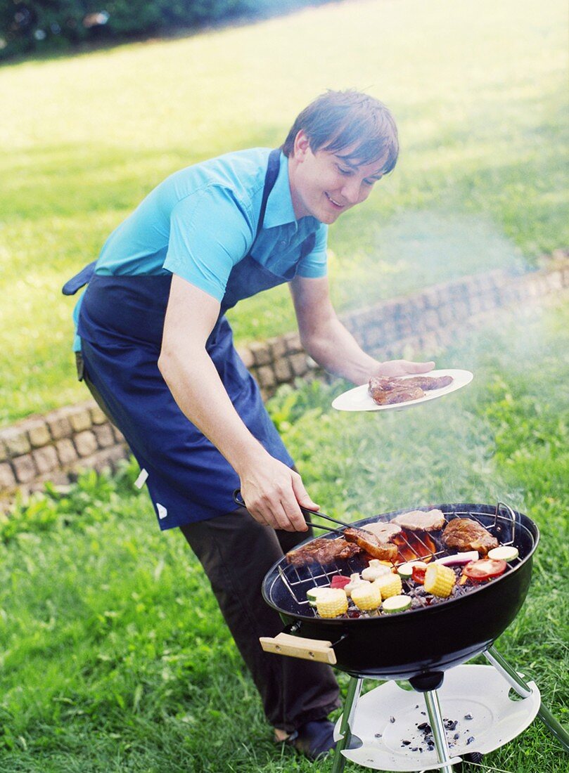 Young man barbecuing food
