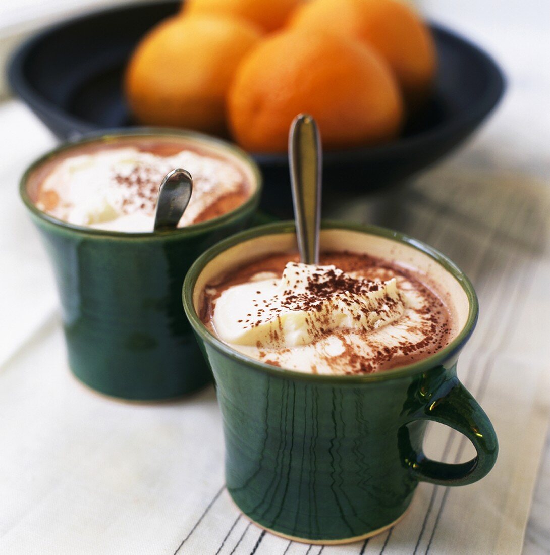 Hot chocolate with cream, oranges in background