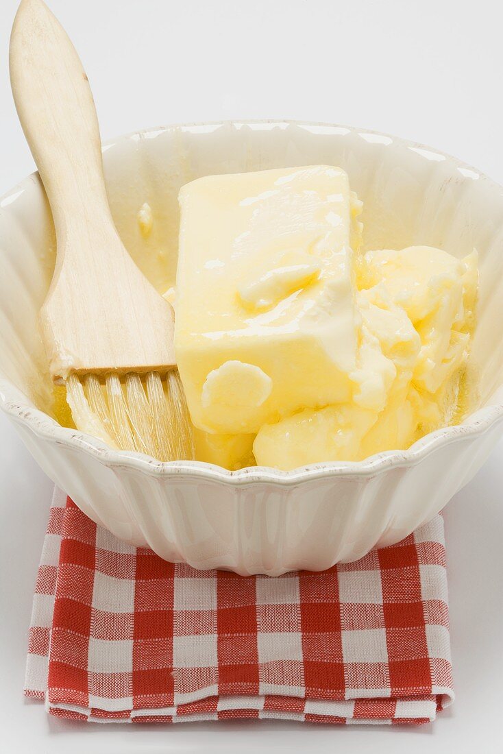 Schmelzende Butter mit Backpinsel in Schale