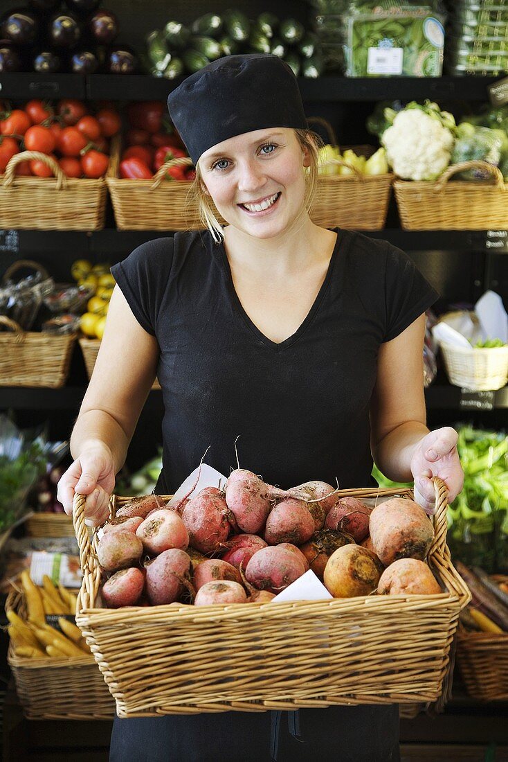 Supermarket employee holding basket of turnips