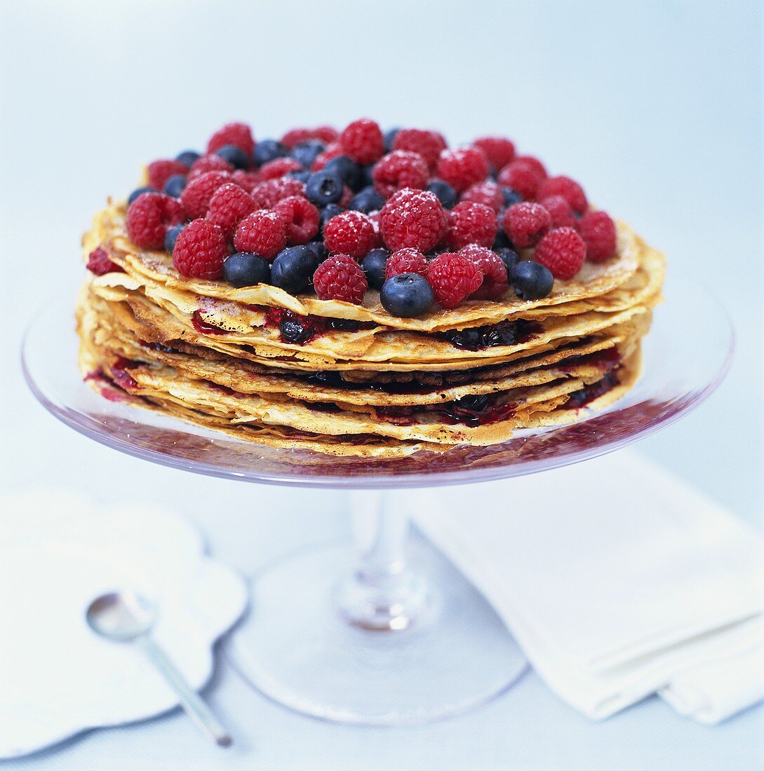 Pancake cake topped with raspberries and blueberries