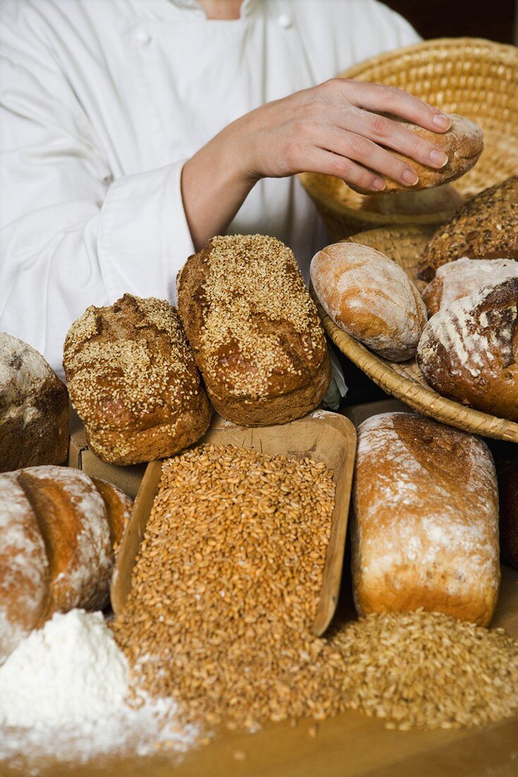 Baker with various types of bread and bread rolls