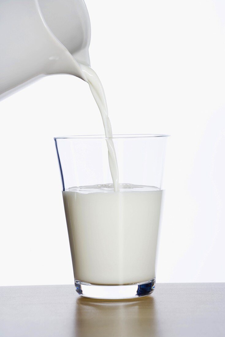 Milch in Glas einschenken