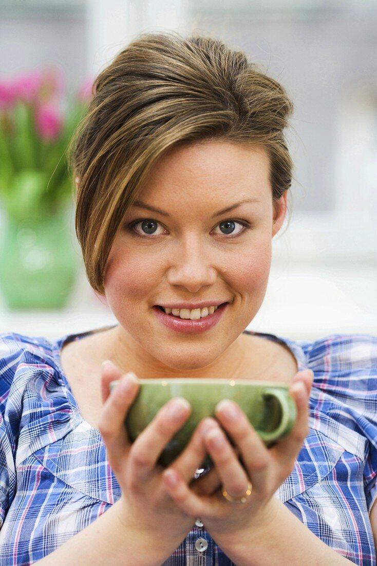 Woman holding cup of tea