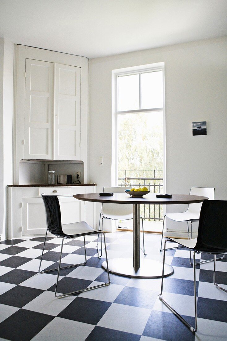 Schwedische Küche in Schwarz-weiß mit Boden im Schachbrettmuster und weißen und schwarzen Möbeln