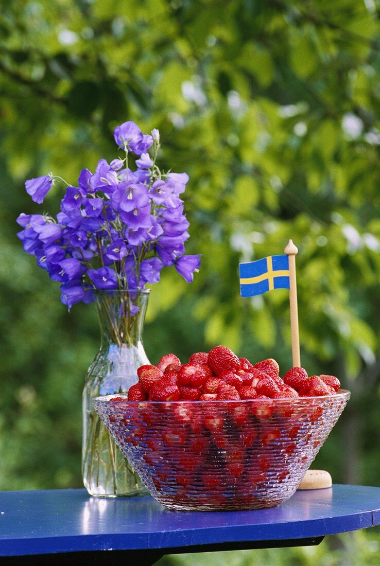 Walderdbeeren in Glasschale auf Gartentisch (Schweden)