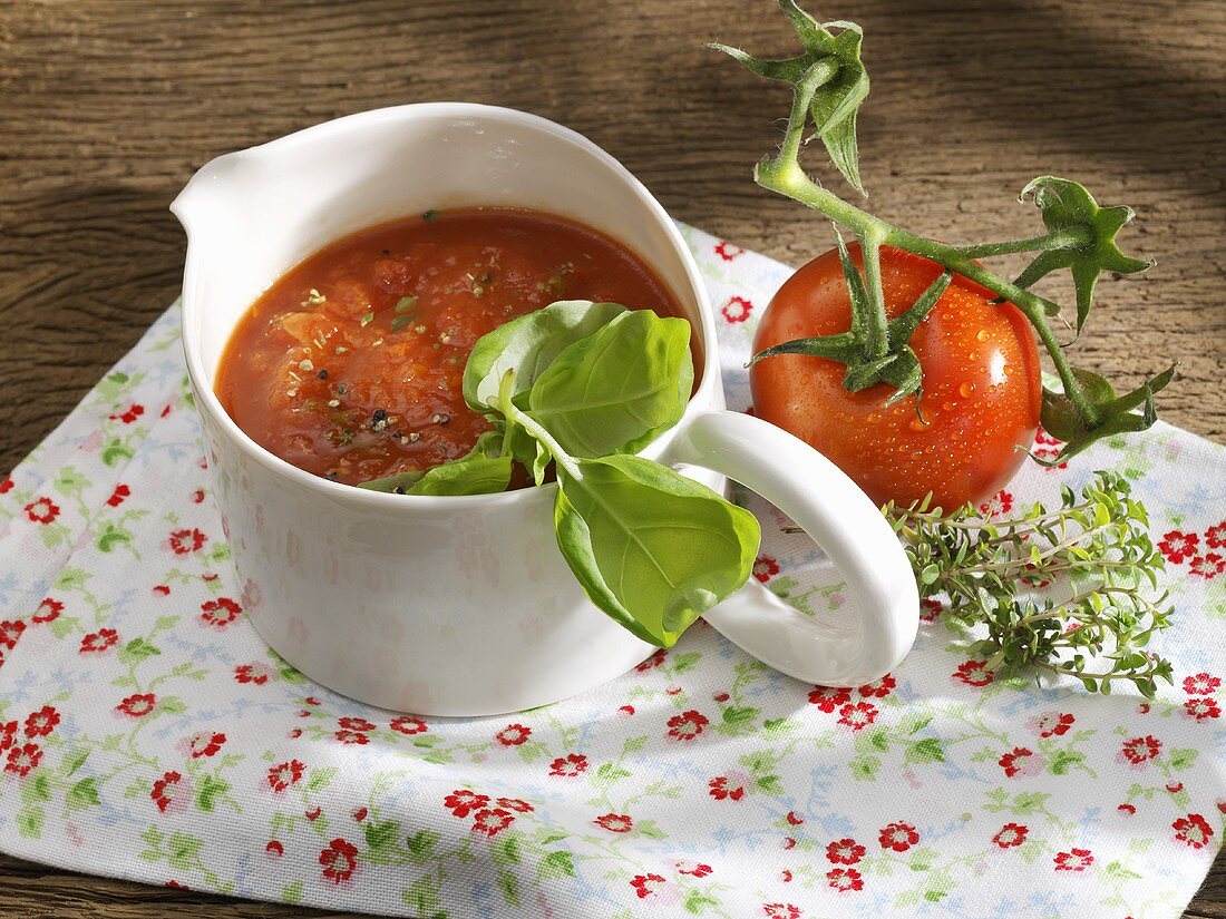 Tomato sauce in jug on floral cloth