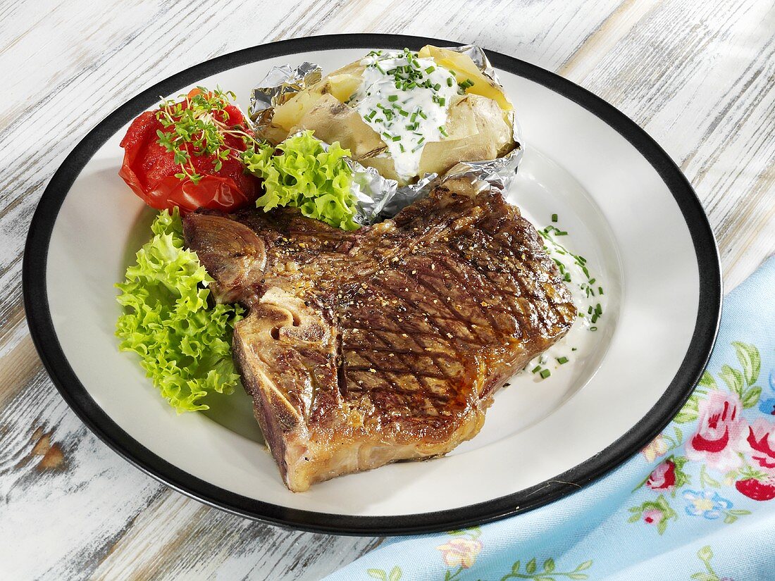 T-bone steak and baked potato with quark and herbs