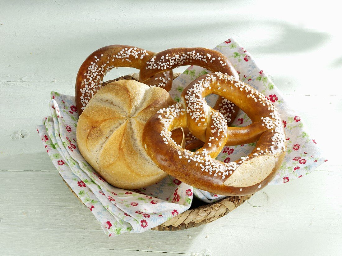 Bread roll and two pretzels in small basket