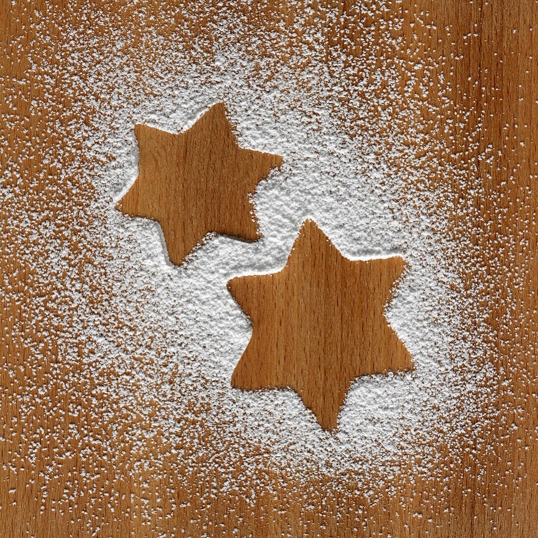 Star shapes in icing sugar on wooden background