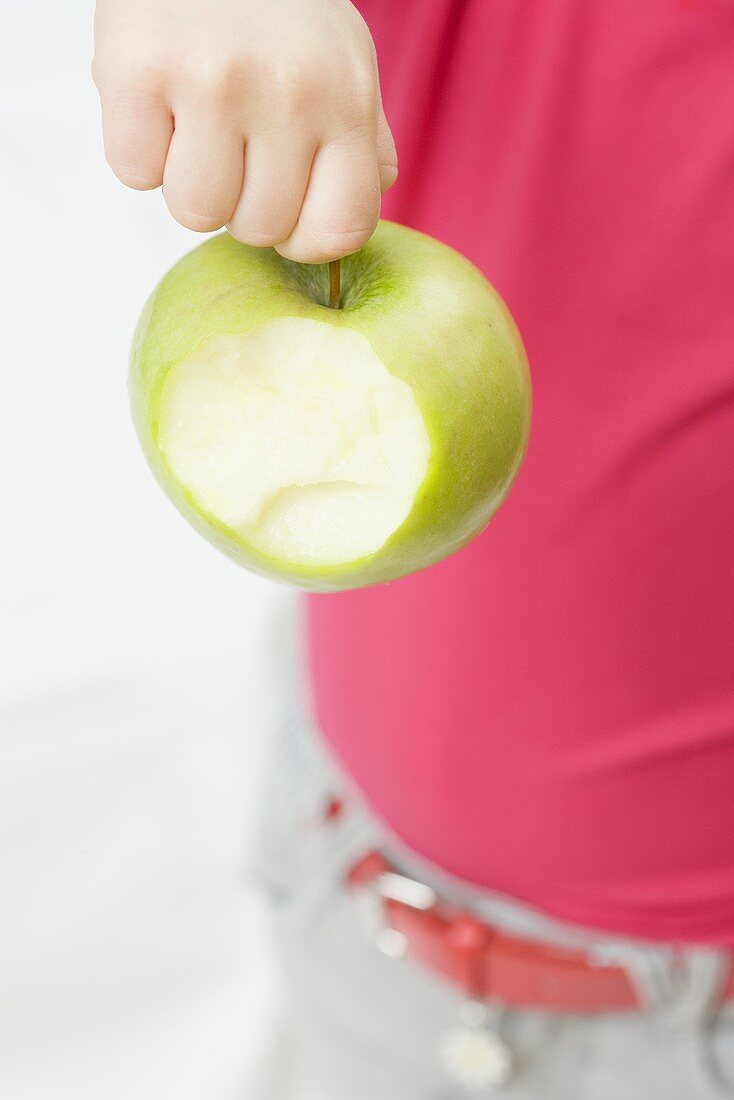 Child holding partly eaten apple