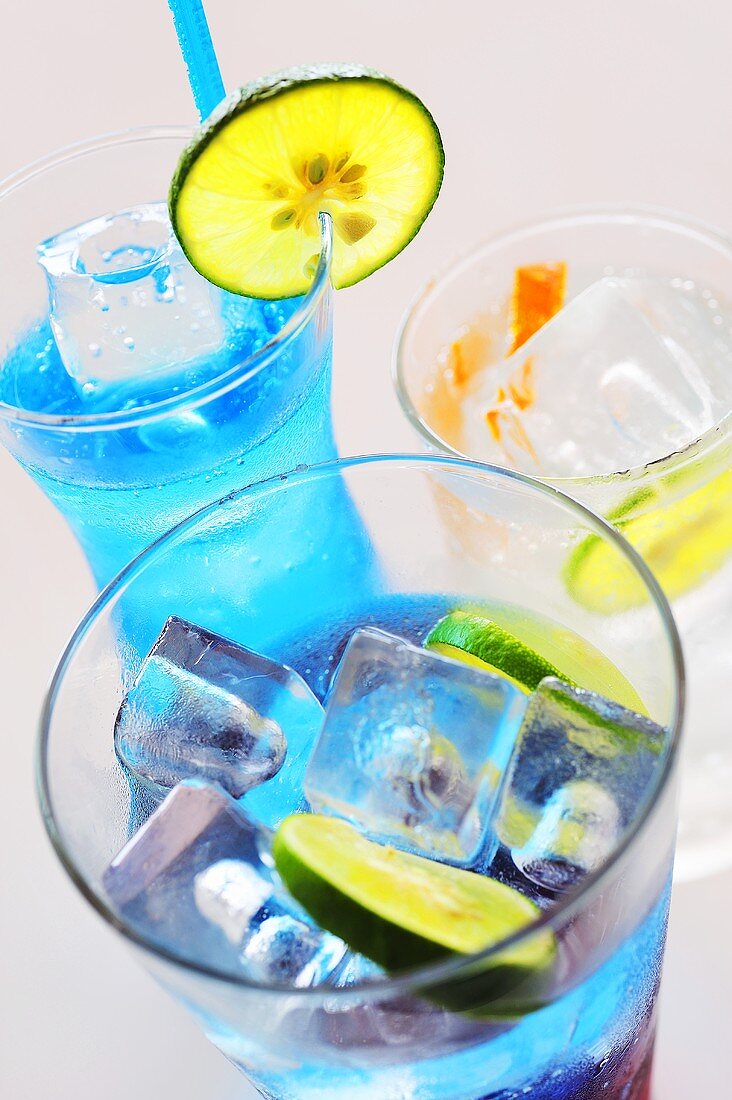 Three soda water drinks with lime on ice