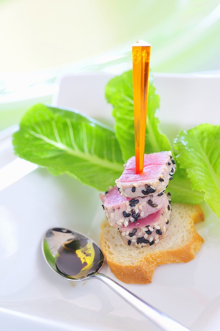 Tuna with sesame seeds and bread on skewer