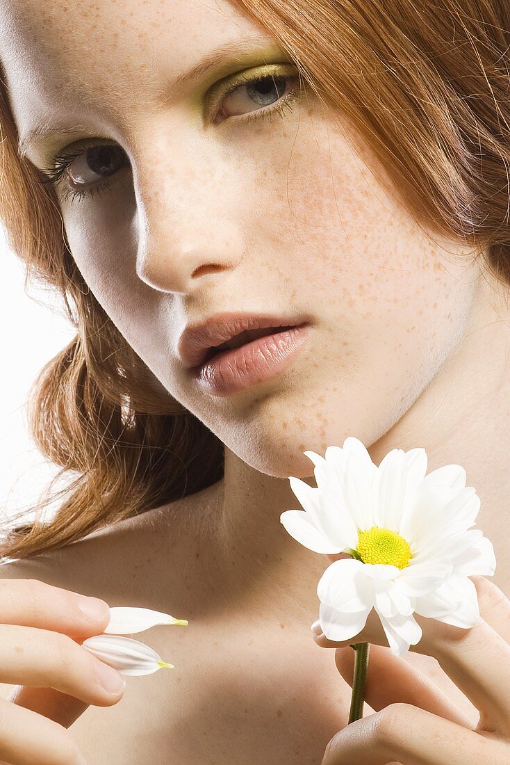 Red-headed woman holding a white flower