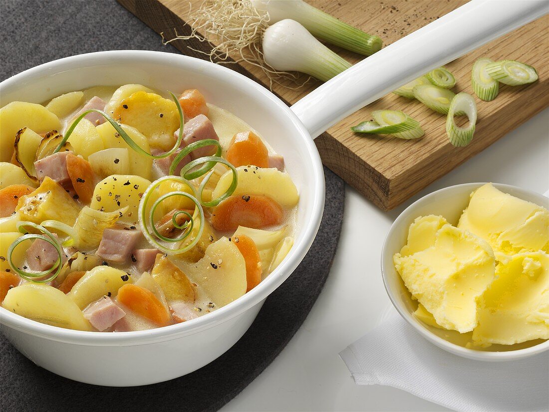 Potato and carrot stew with cured pork and spring onions