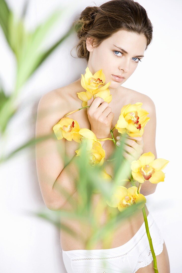 Young woman with yellow orchids