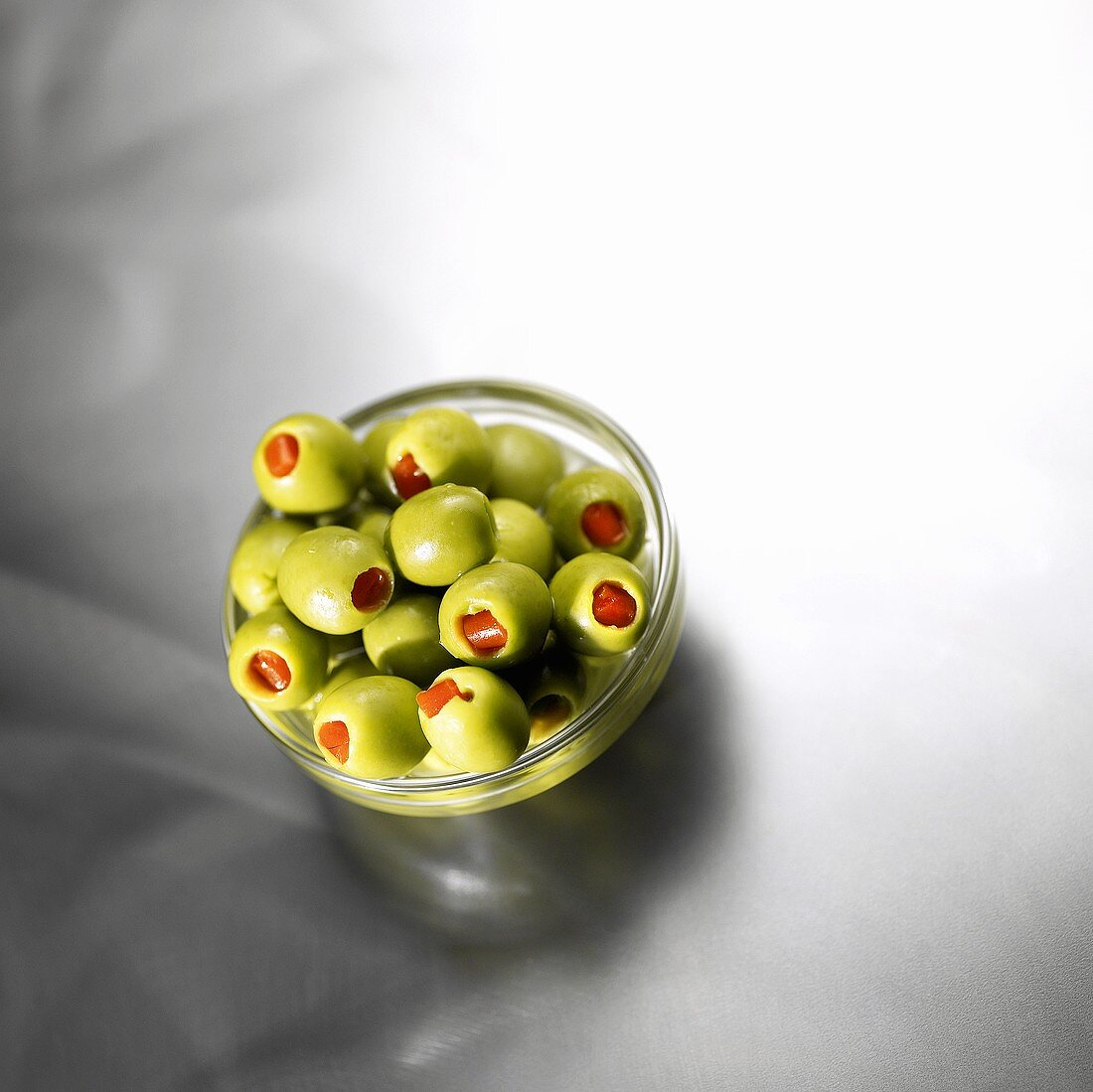 Stuffed green olives in glass dish