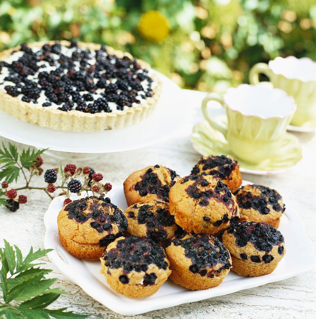 Blackberry tart and blueberry muffins on table out of doors