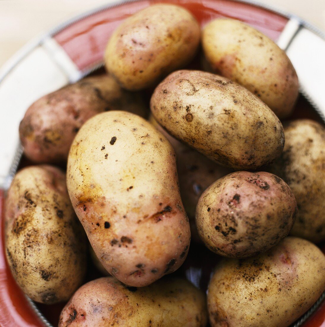 Fresh potatoes in a bowl (overhead view)