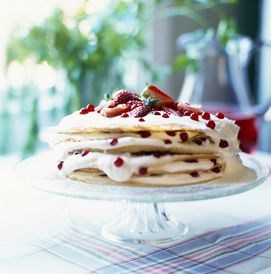 Pancake cake filled with berries and cream (close-up)