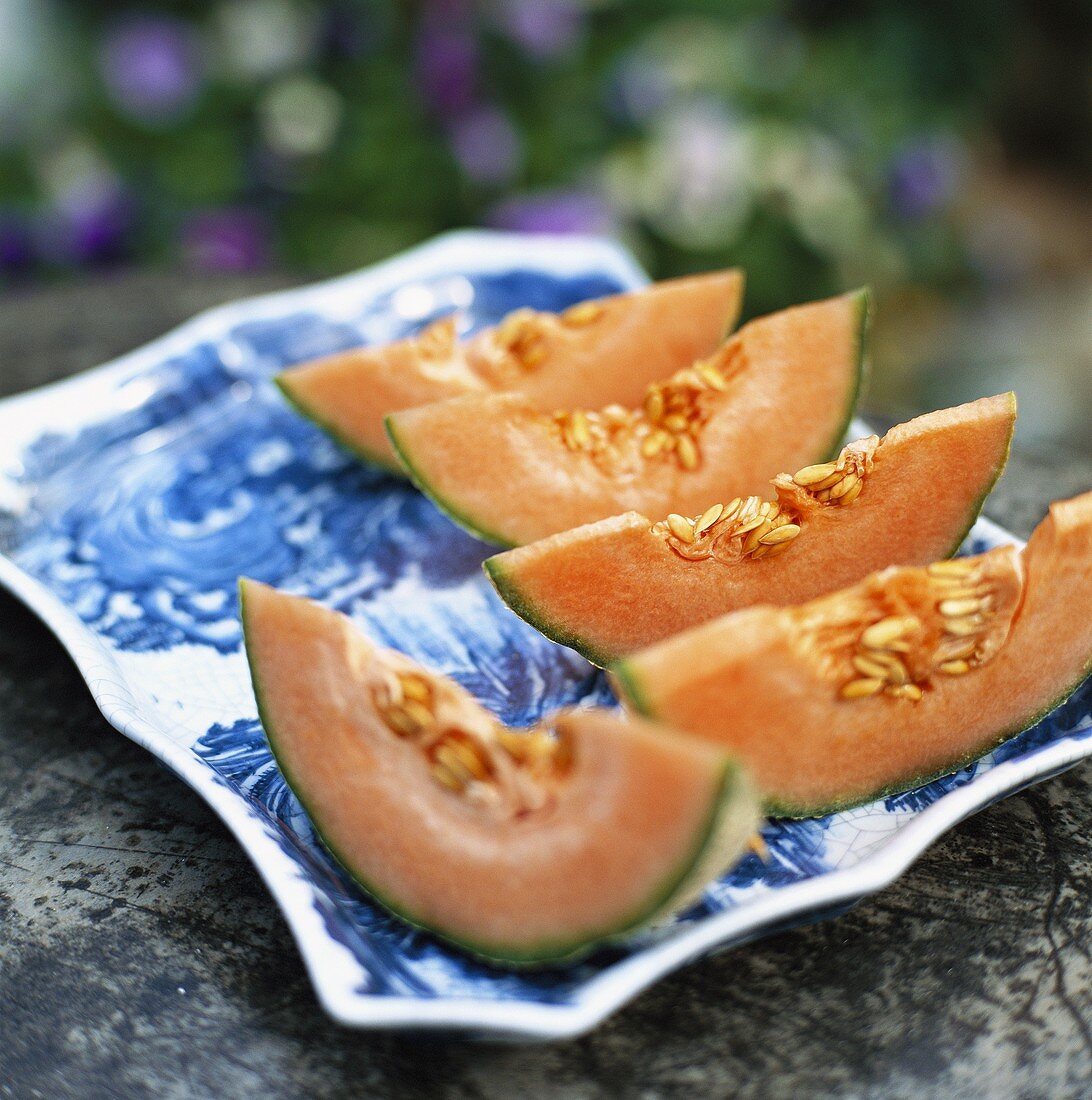 Slices of cantaloupe melon on porcelain plate