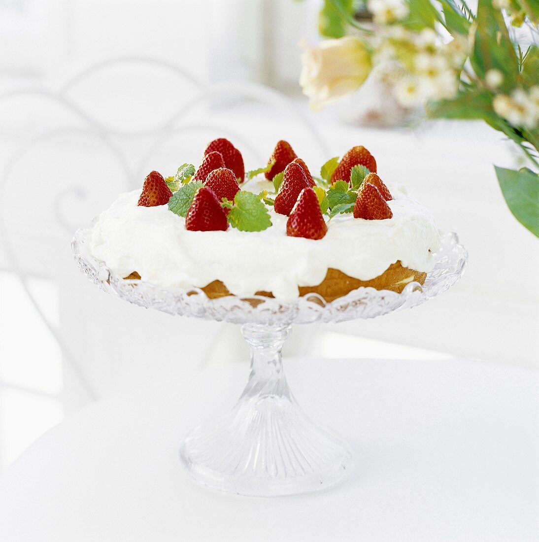 Kuchen mit Sahne und Erdbeeren auf Tortenständer