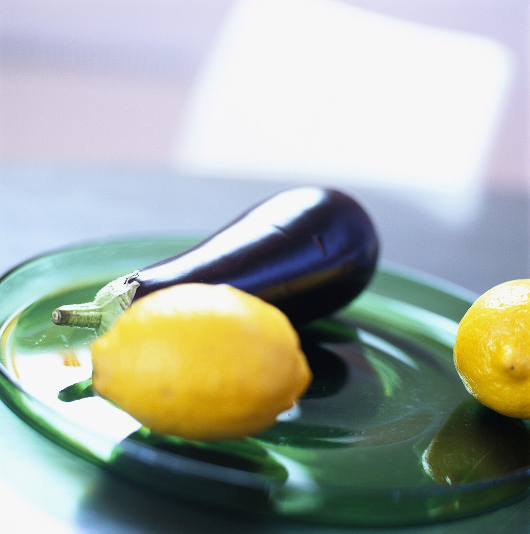 Lemons and aubergine on green plate