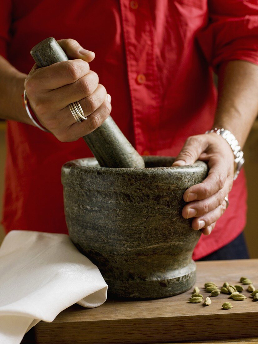 Person grinding spices in a mortar