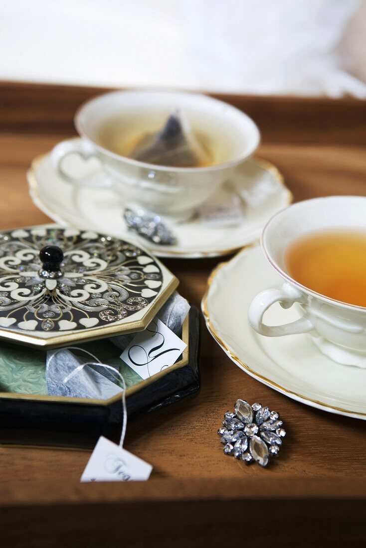 Teetassen und Teebeutel auf Tablett