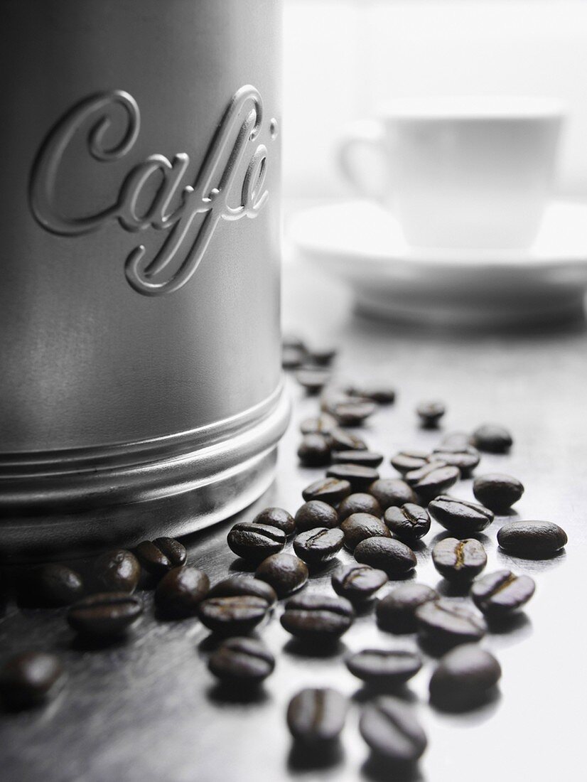 Coffee beans beside coffee tin